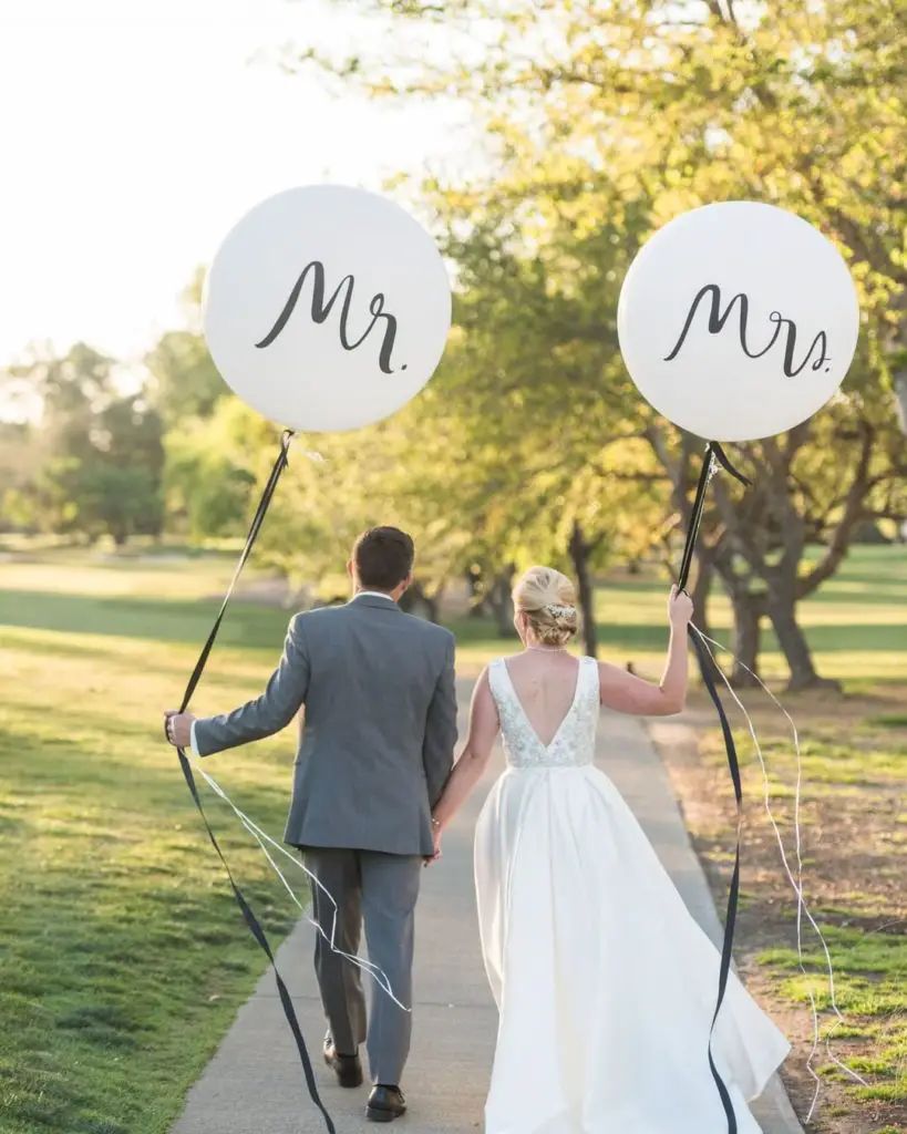 Golf Themed Wedding Ideas & Inspiration. Bride and Groom on a golf course holding Mr. and Mrs. balloons