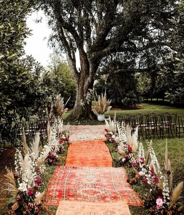 Outdoor Fall Wedding Pampas Grass, burgundy blush flowers, and Masada rugs Aisle Decorations